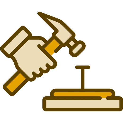 Hand holding a hammer about to hit a nail into a wooden surface.