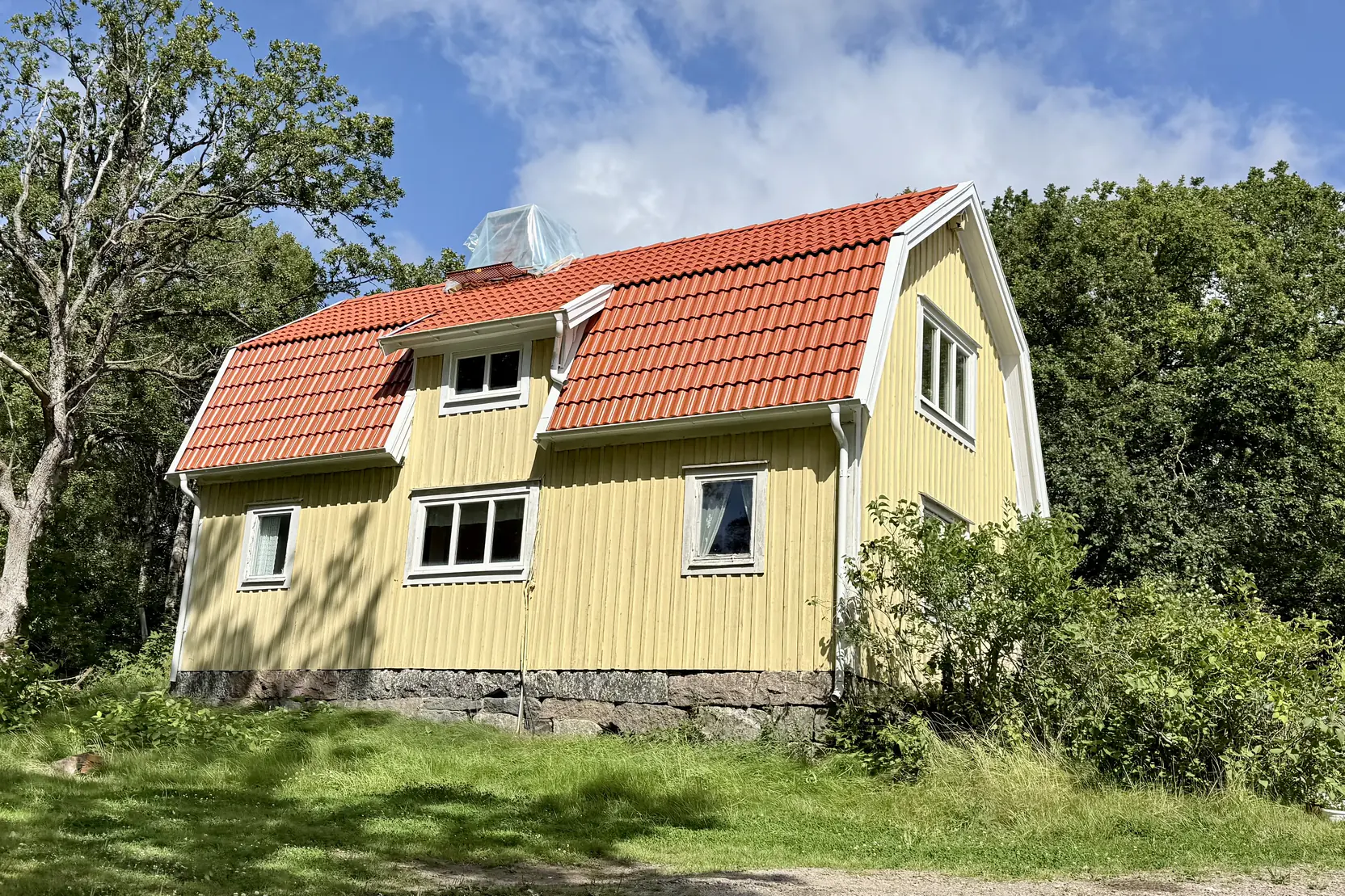 Nytt rött tegeltak på gult 1½-planshus utanför Uddevalla