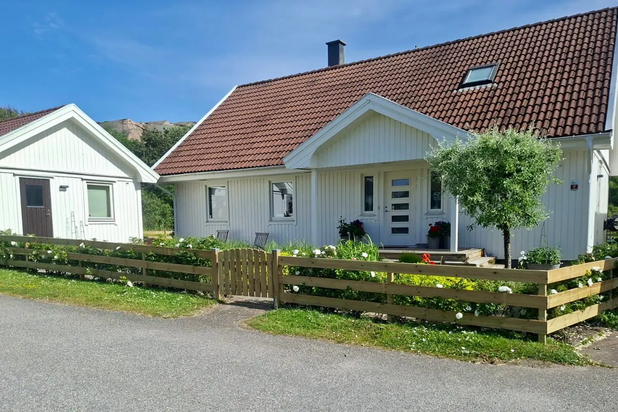 Trästaket runt trädgården vid ett vitt hus i Uddevalla