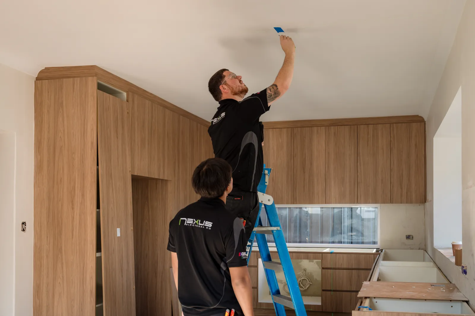 Nexus Electrical Co electricians installing a ceiling light in a City Beach home