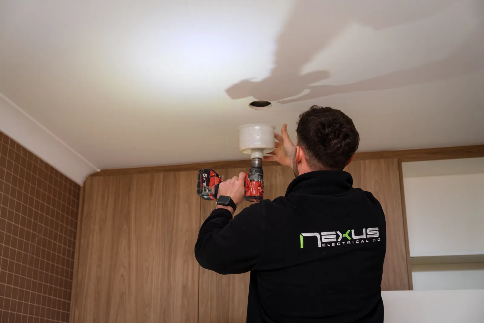 Nexus Electrical Co electrician installing a ceiling light in a Carine home
