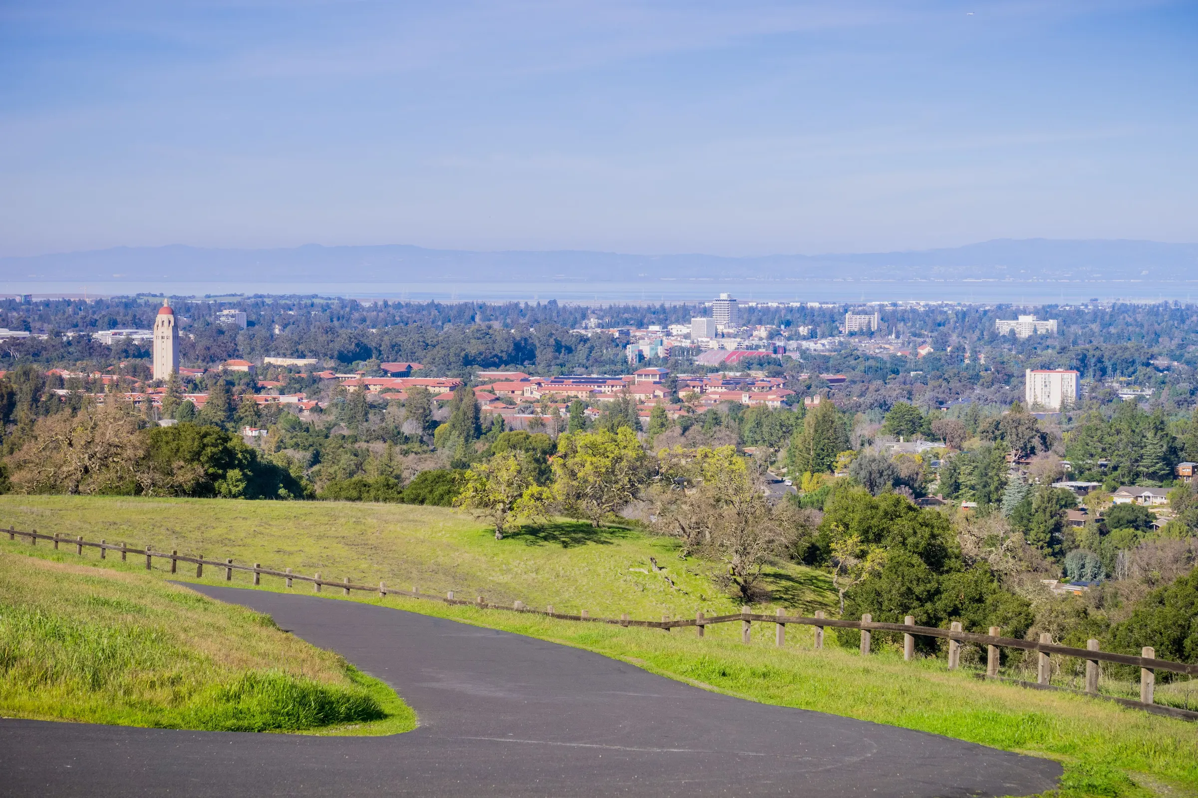 View across Palo Alto, California from the foothills, Stanford's red-tiled roofs and Hoover Tower among the oaks with San Francisco Bay beyond
