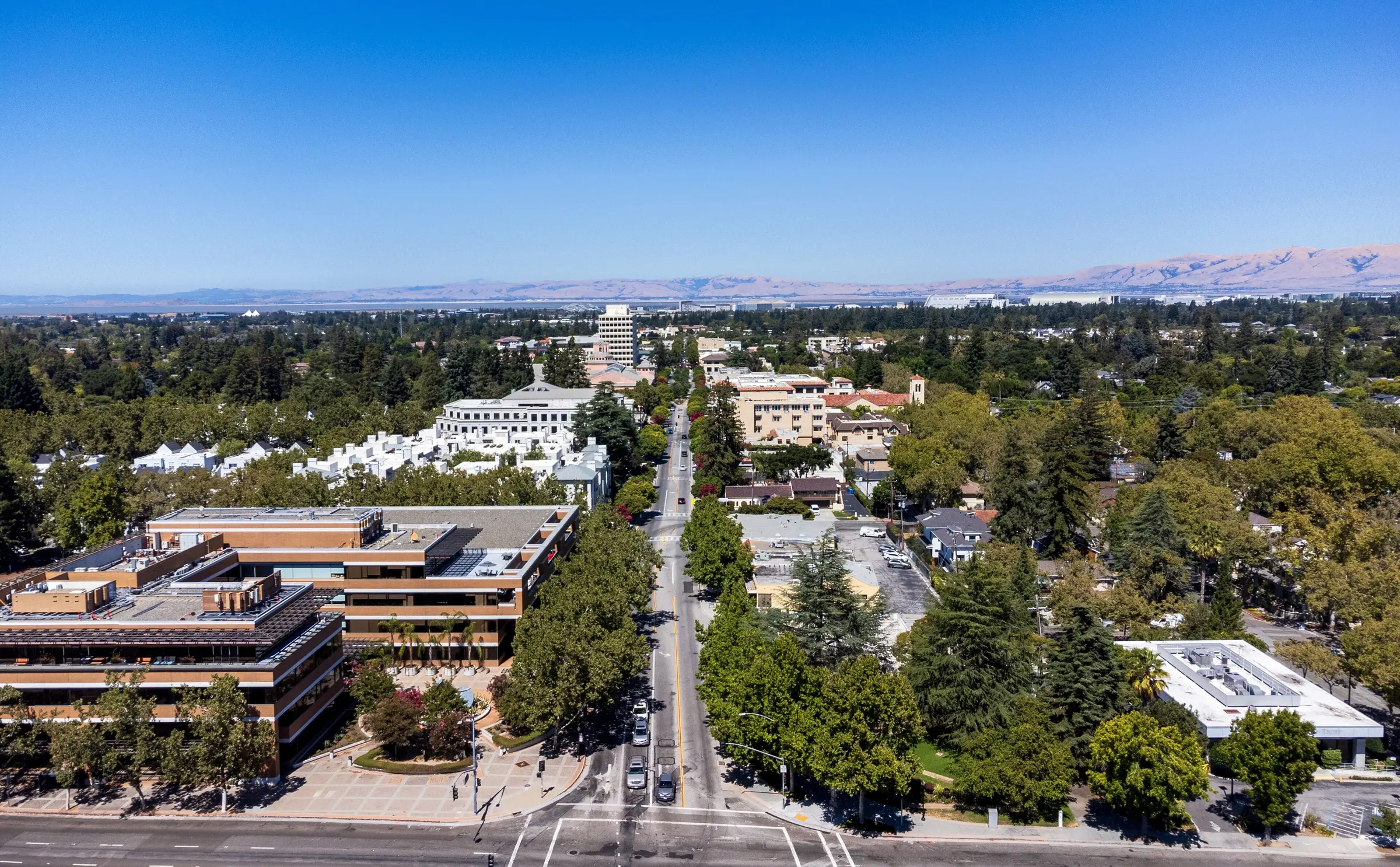 Aerial view along Castro Street in Mountain View, California, tree-lined downtown running north toward San Francisco Bay and the Diablo Range
