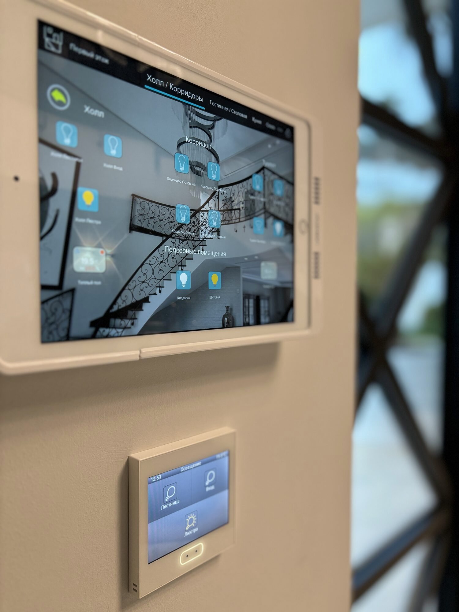 Wall-mounted touchscreens displaying room and lighting controls