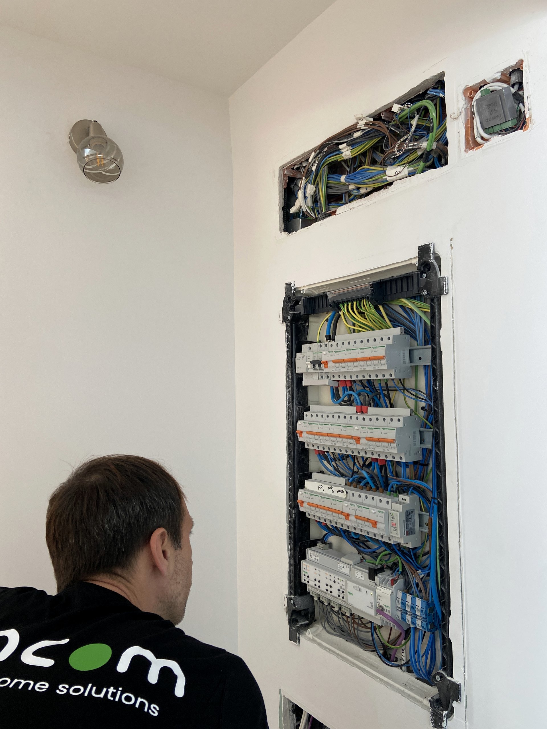 UNCOM technician working on an open residential electrical cabinet