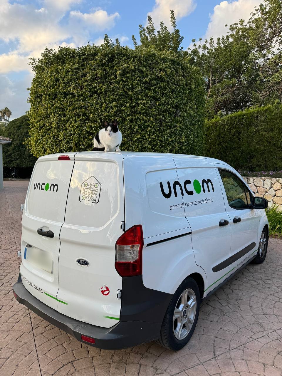 UNCOM service van with a cat sitting on its roof