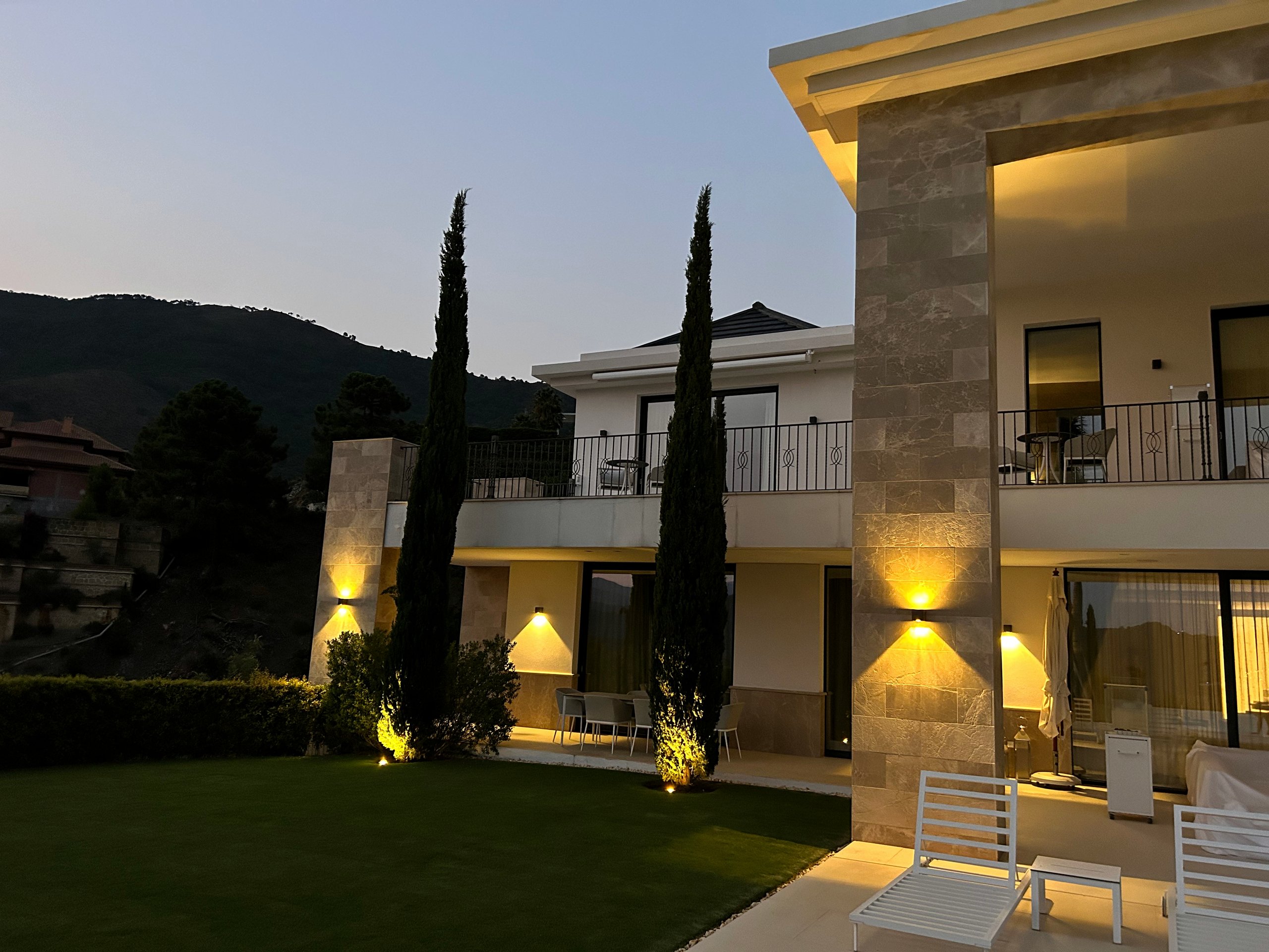 Rear facade and garden of a modern villa illuminated at dusk