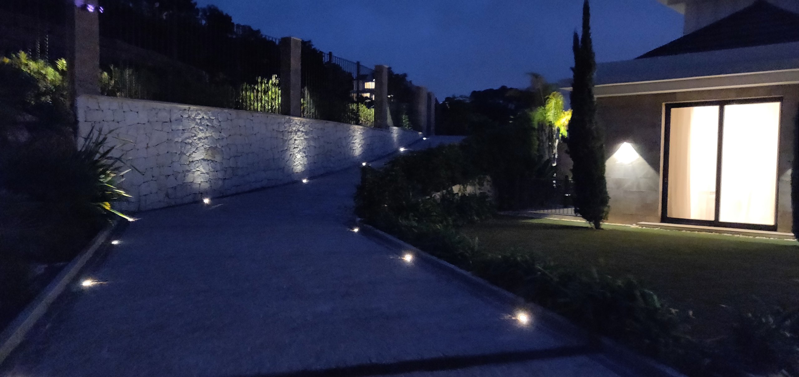 Villa driveway with integrated path and retaining-wall lighting