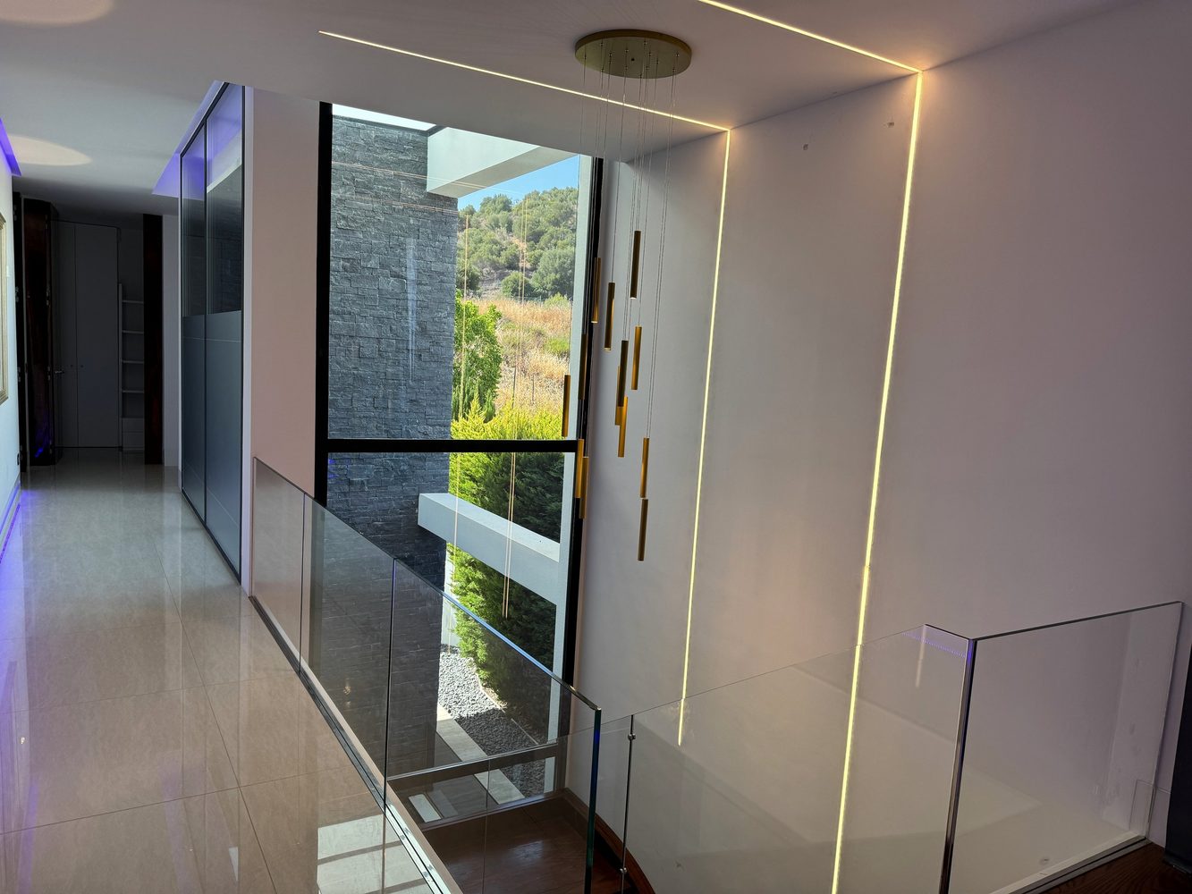 Upper landing with architectural linear lighting and glazed stairwell