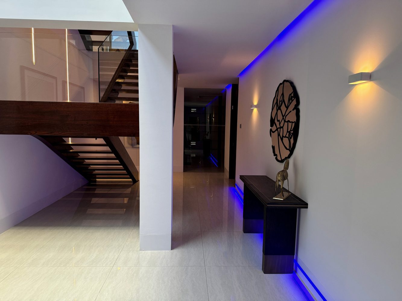 Villa staircase and corridor with wall lights and blue linear lighting