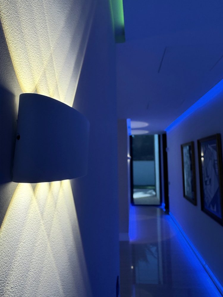 Wall-light detail with warm illumination and blue corridor lighting
