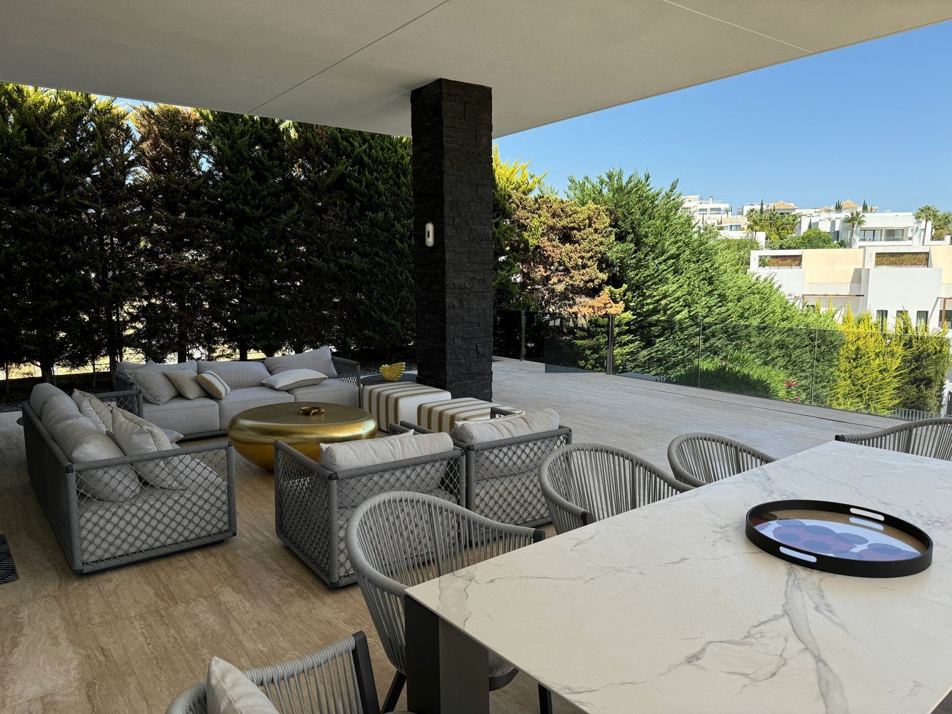 Covered villa terrace with outdoor seating and garden views