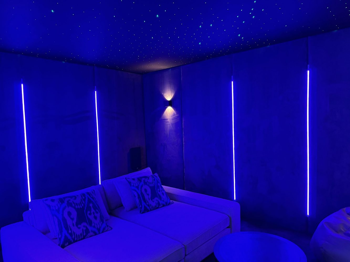 Home cinema seating beneath a star ceiling and blue light scene