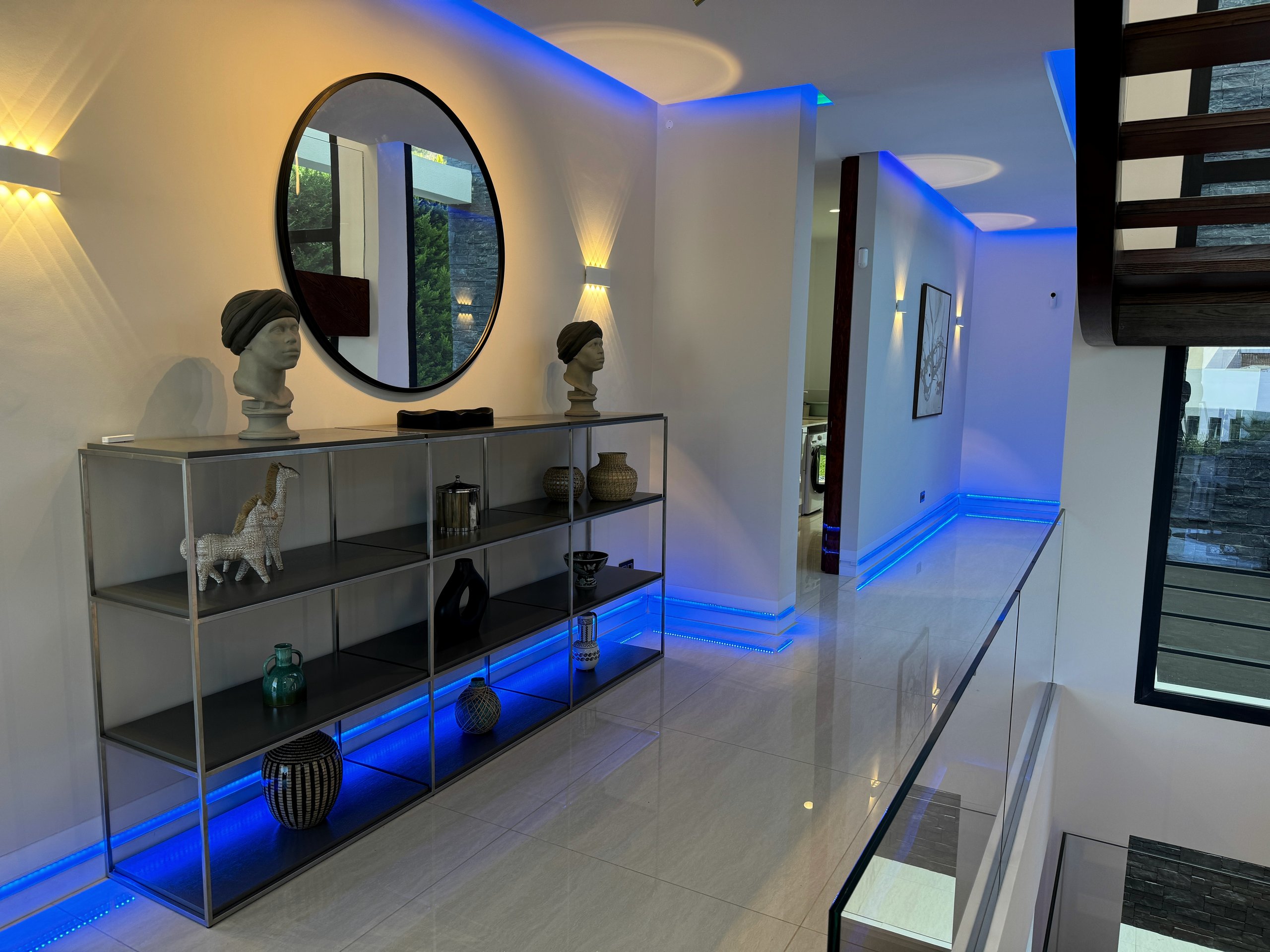Hallway with layered wall and linear lighting in a modern villa