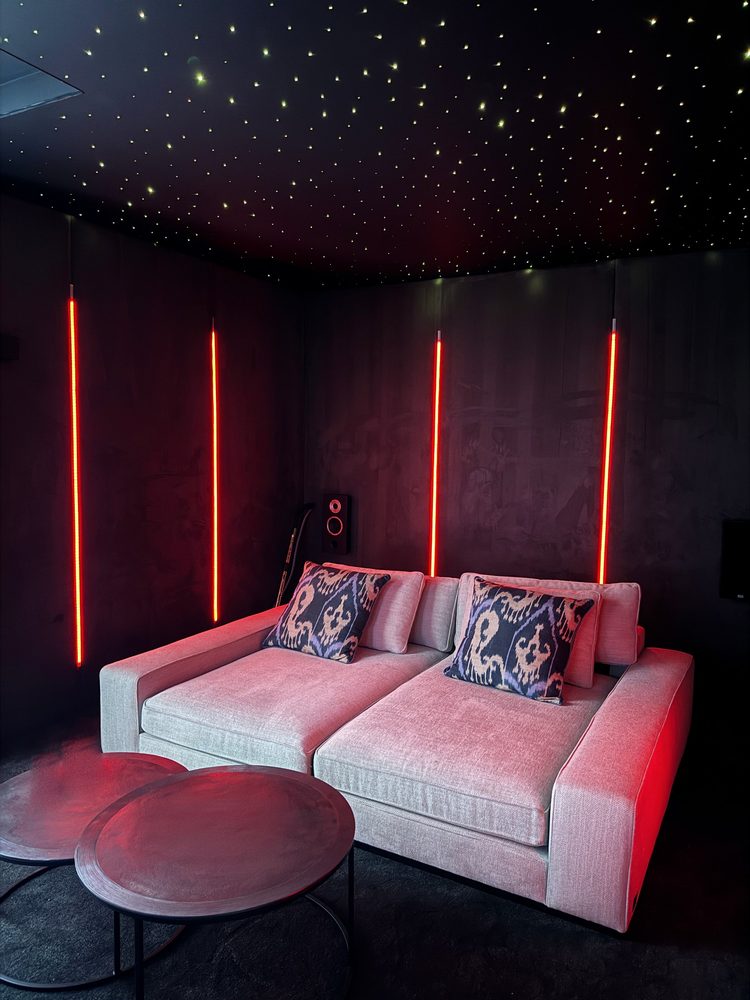 Home cinema with red lighting, star ceiling and lounge seating