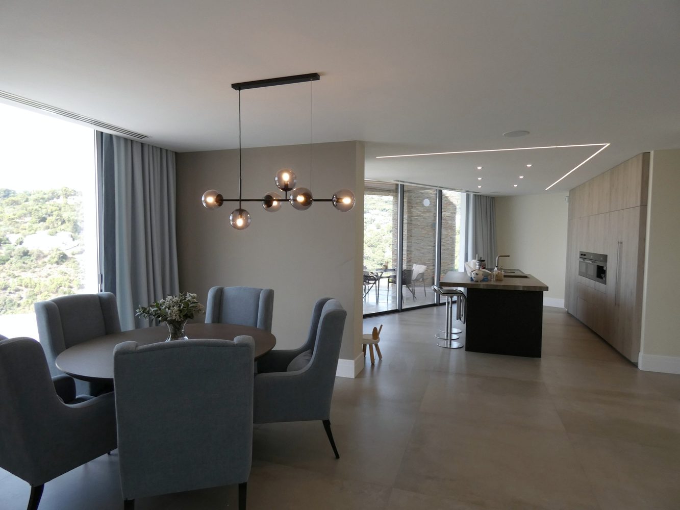 Open-plan dining and kitchen area with integrated ceiling lighting