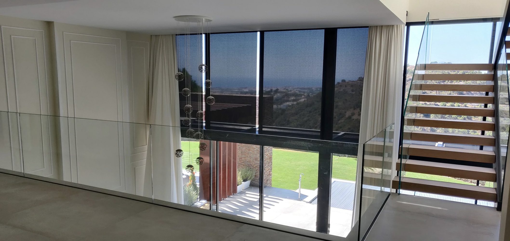 Double-height glazing, automated curtains and a floating staircase