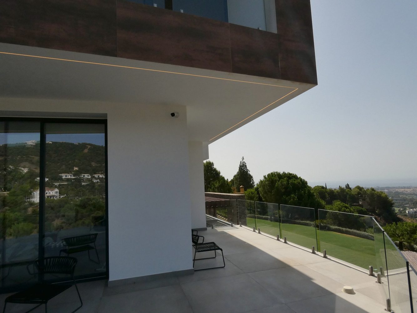 Villa terrace with discreetly integrated exterior security equipment