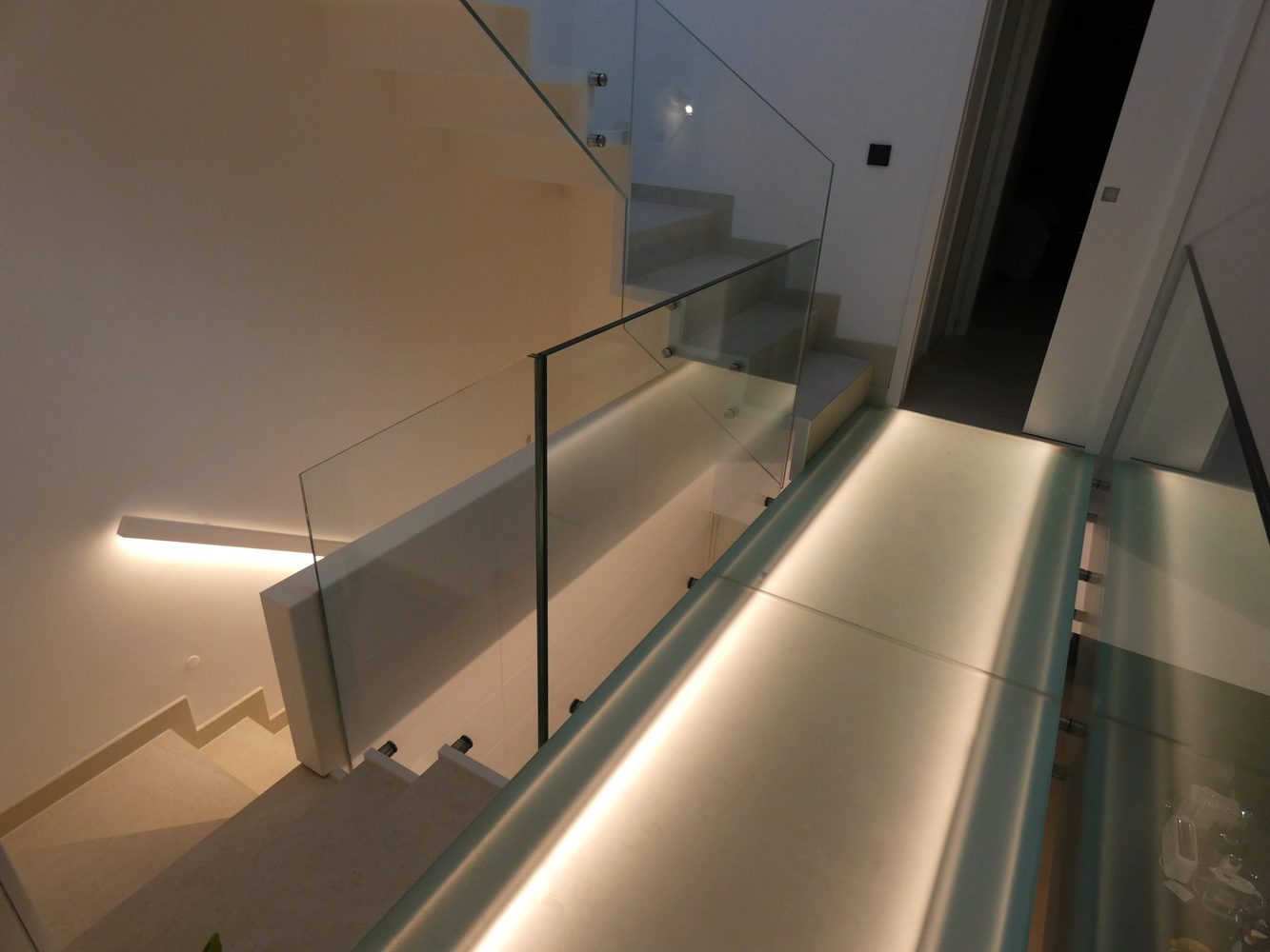 Linear lighting integrated into a glass staircase in an Estepona townhouse