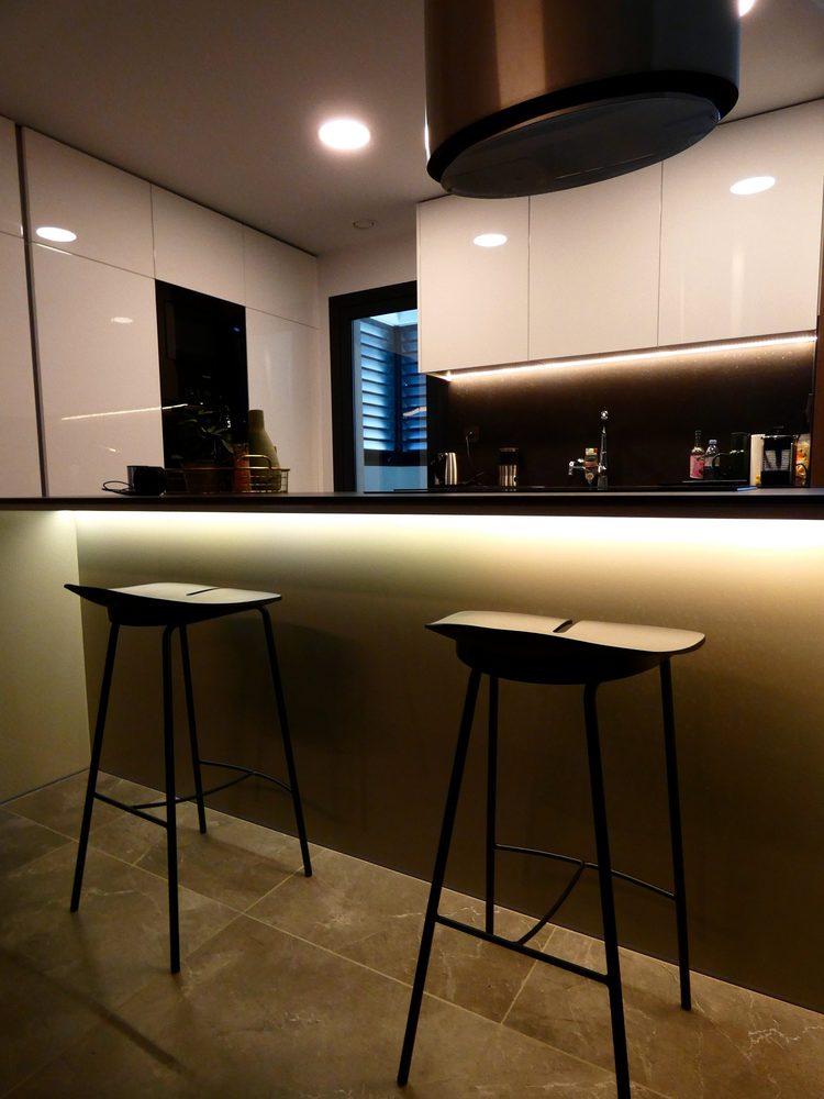 Portrait view of the kitchen bar and warm linear lighting