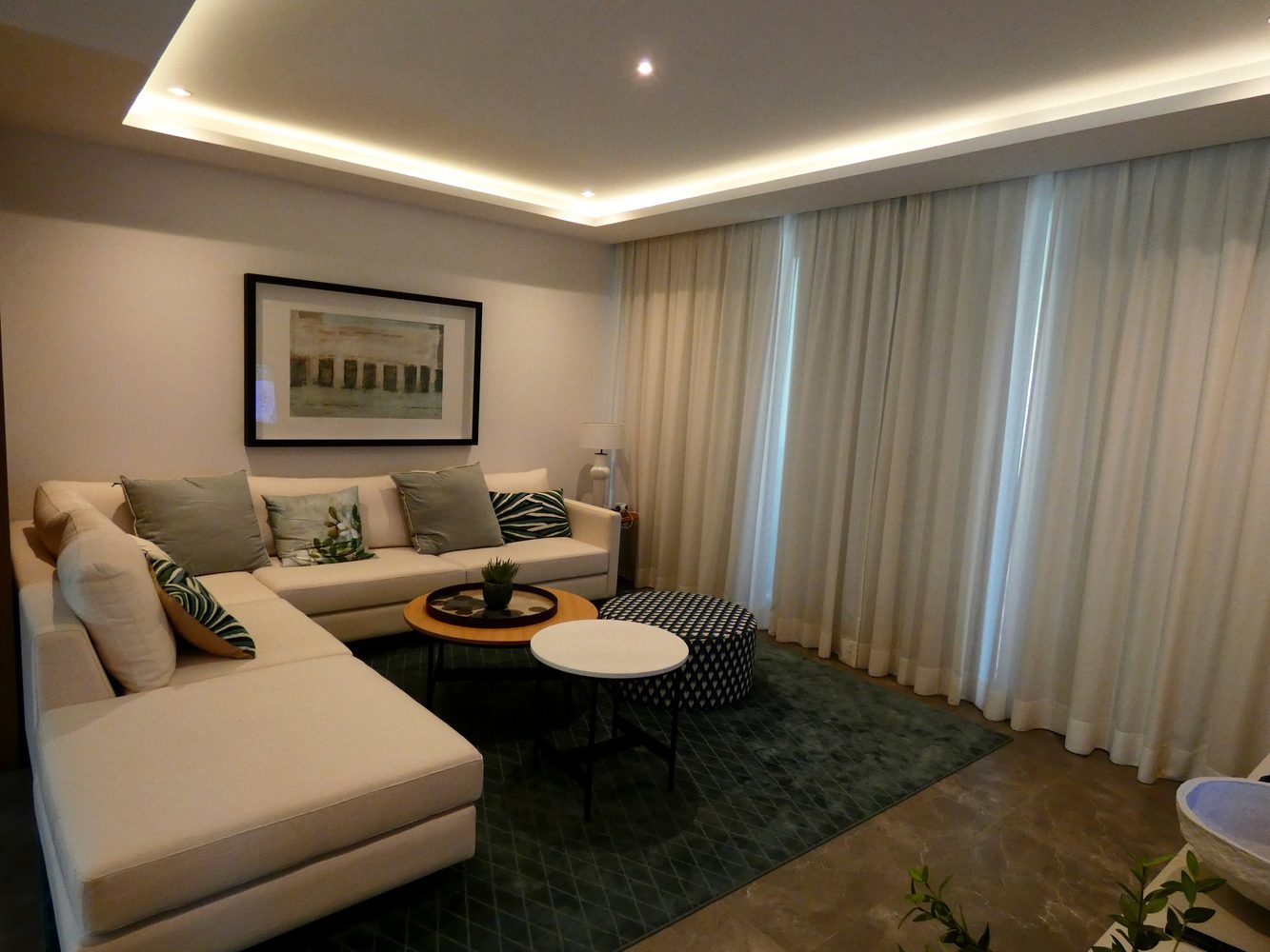 Living room with layered cove lighting and full-height curtains