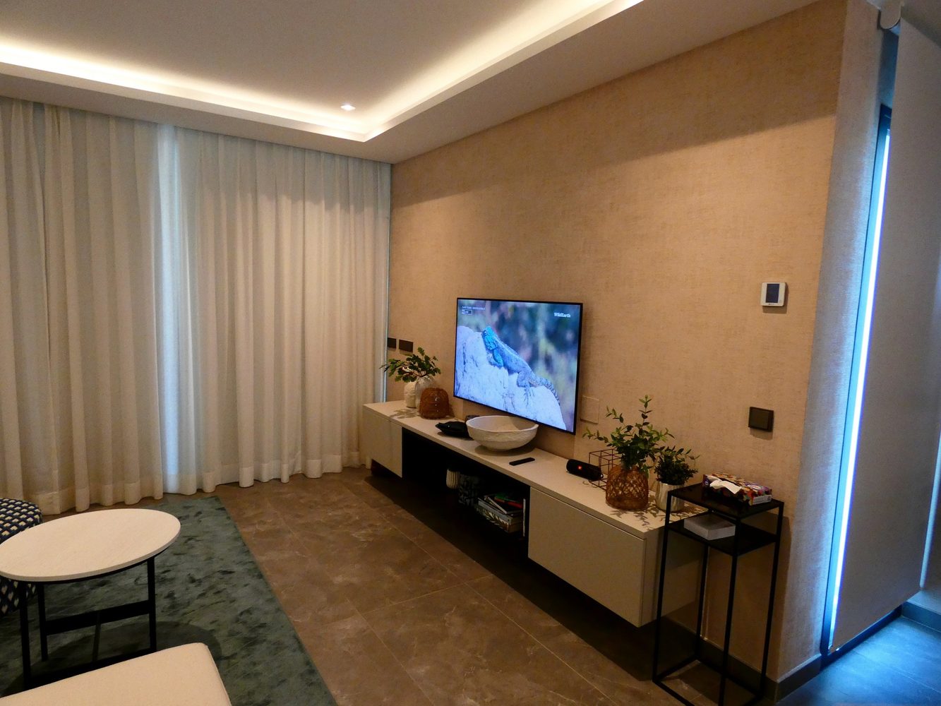 Living room media area with television and architectural lighting