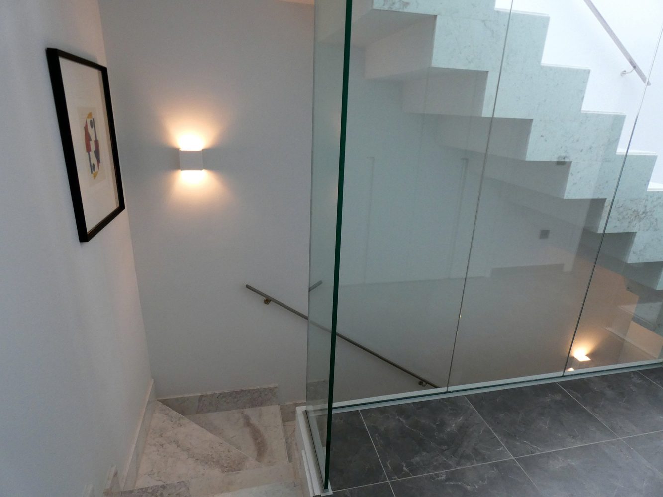 Staircase with glass balustrade and integrated wall lighting
