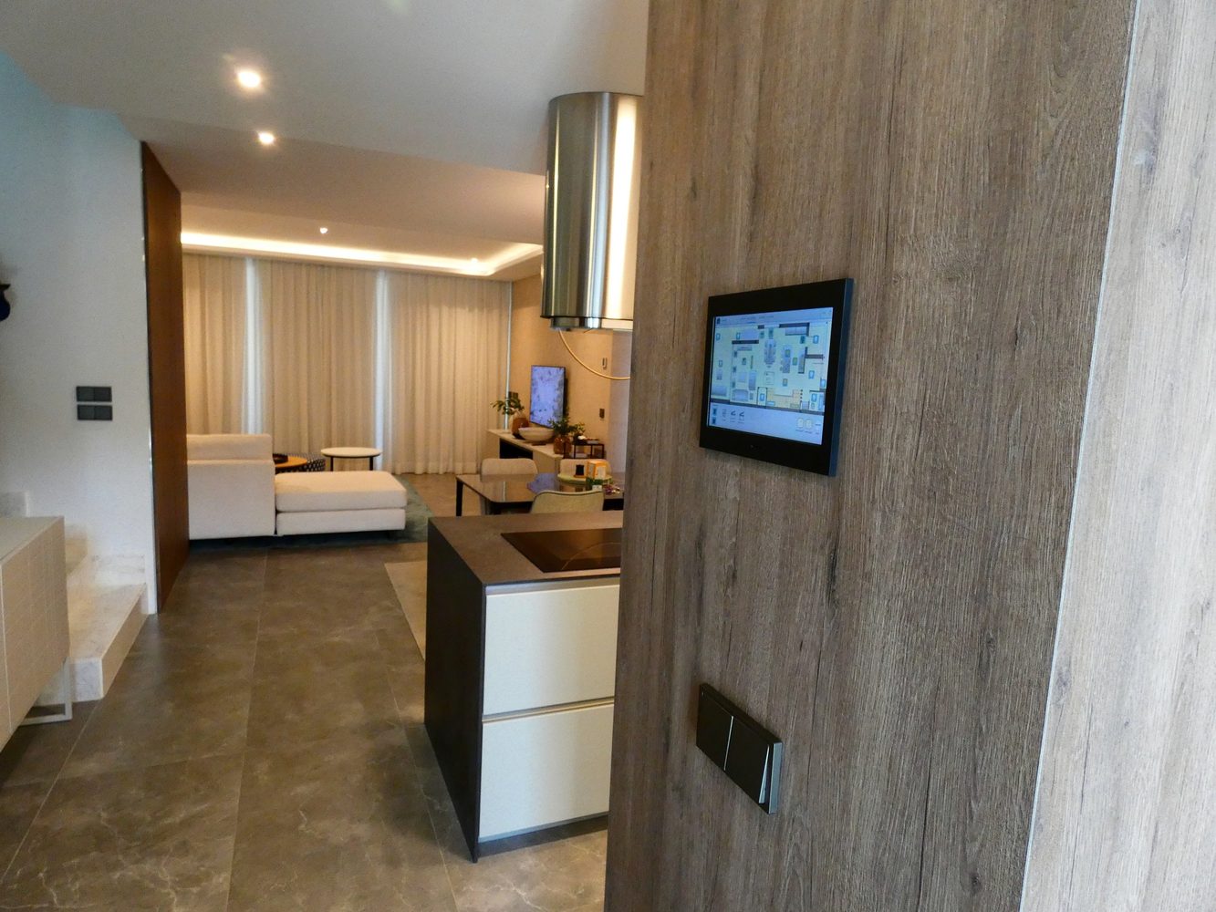 Smart-home touchscreen shown in the open-plan living area