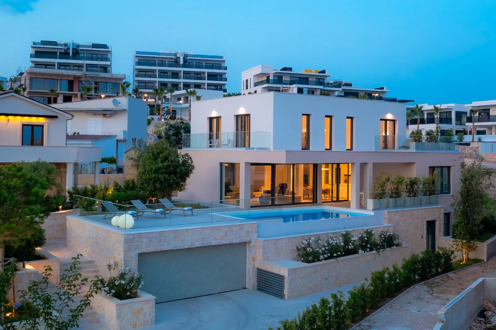 The villa at dusk with the pool lit