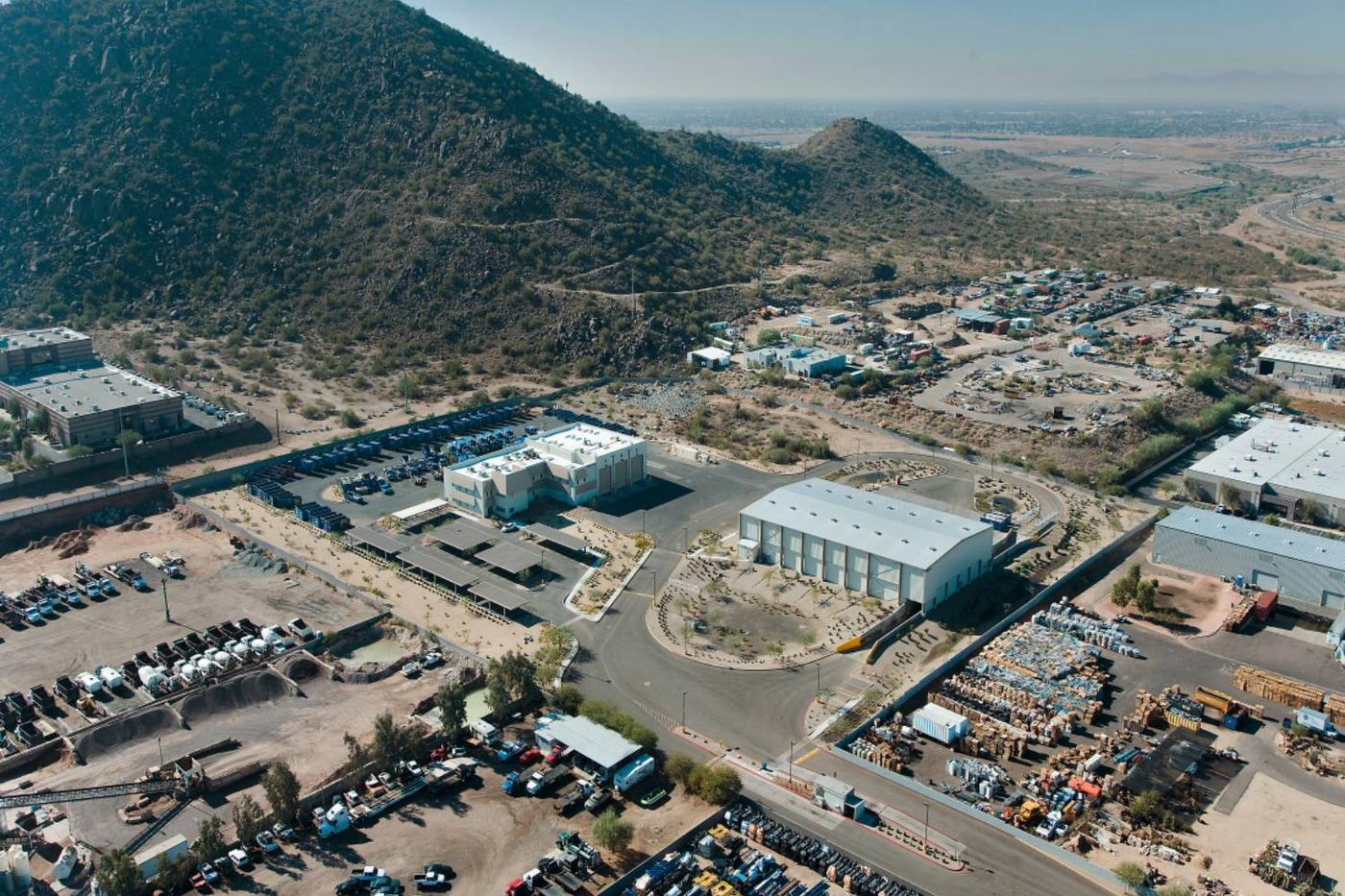 Aerial view of a waste facility and operations yard at the base of a desert mountain