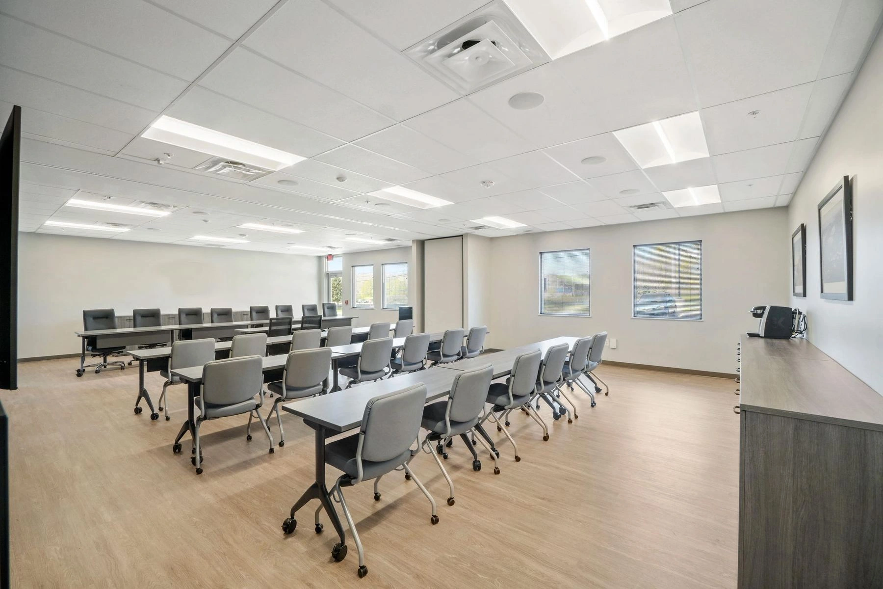 Training room with rows of tables and chairs and windows along one wall