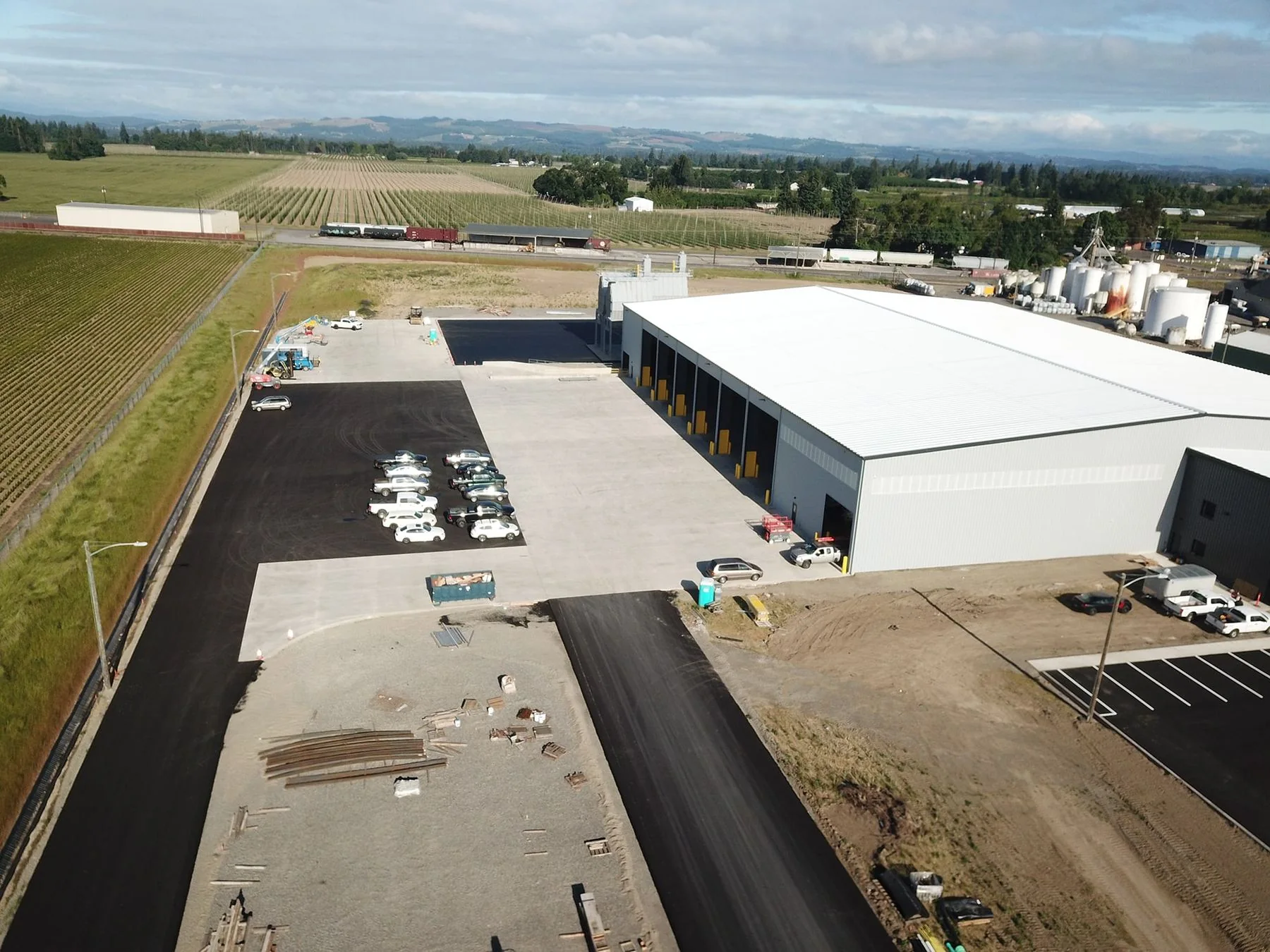 Aerial view of the MRRF C&D processing facility with a white roof beside farmland