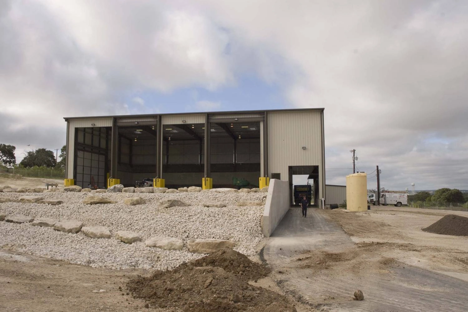 Exterior of the Kerrville transfer station with its approach ramp and gravel apron