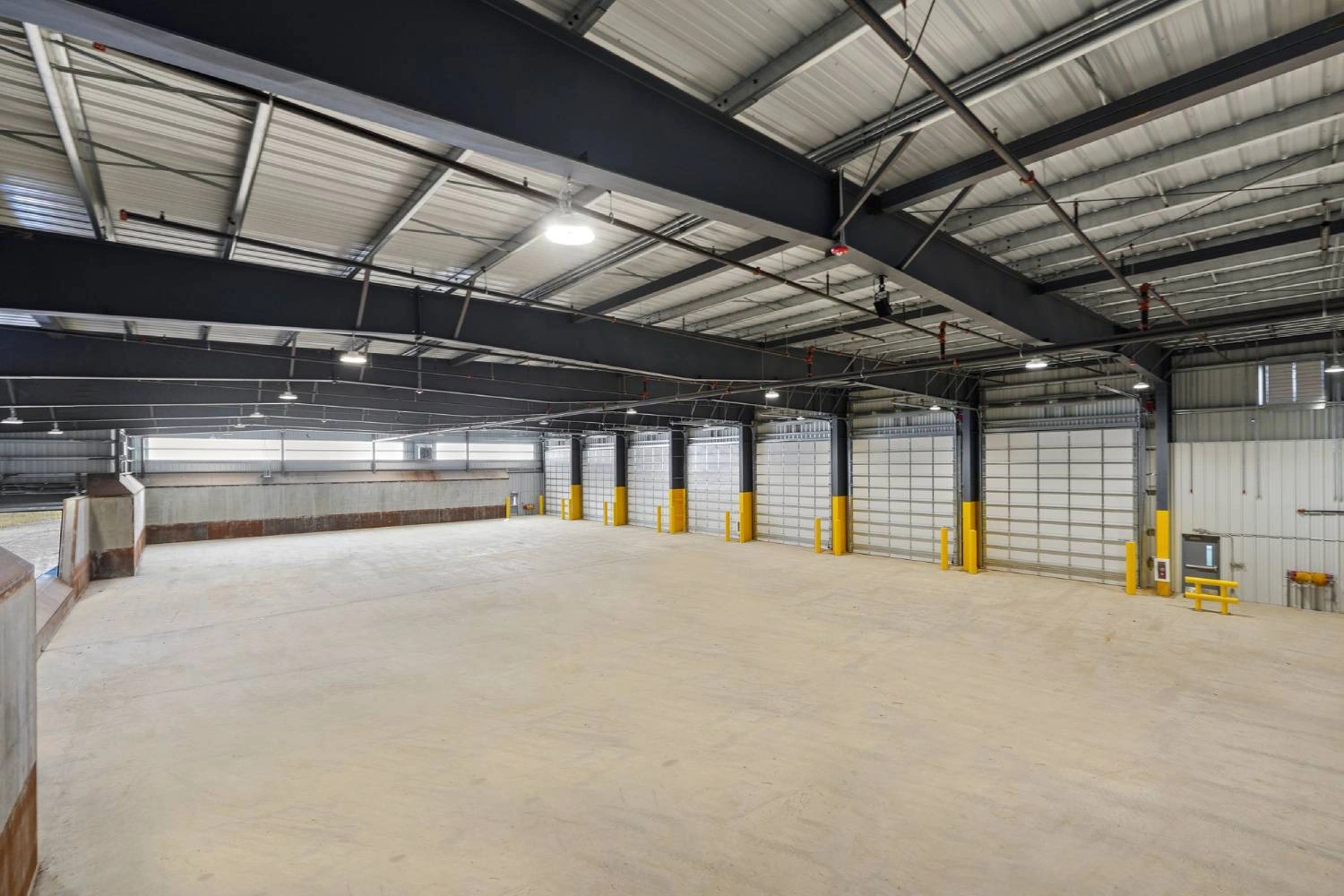 Interior of the RIRRC transfer building with a clear-span roof and yellow bollards