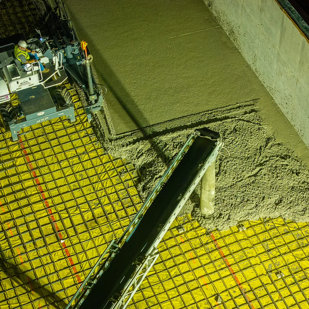 Construction to pour and smooth fresh concrete over a grid-reinforced surface for a material recovery facility. 