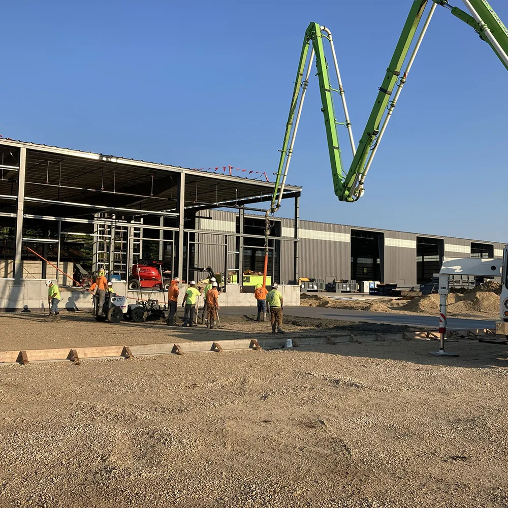 Construction at a material recovery facility and pouring concrete near the partially built pre-engineered metal building.