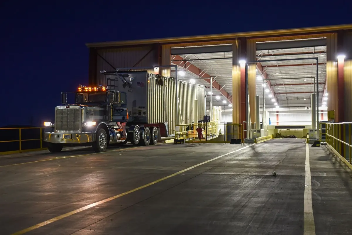 Truck at the Fulcrum processing building drive-through bay lit at night