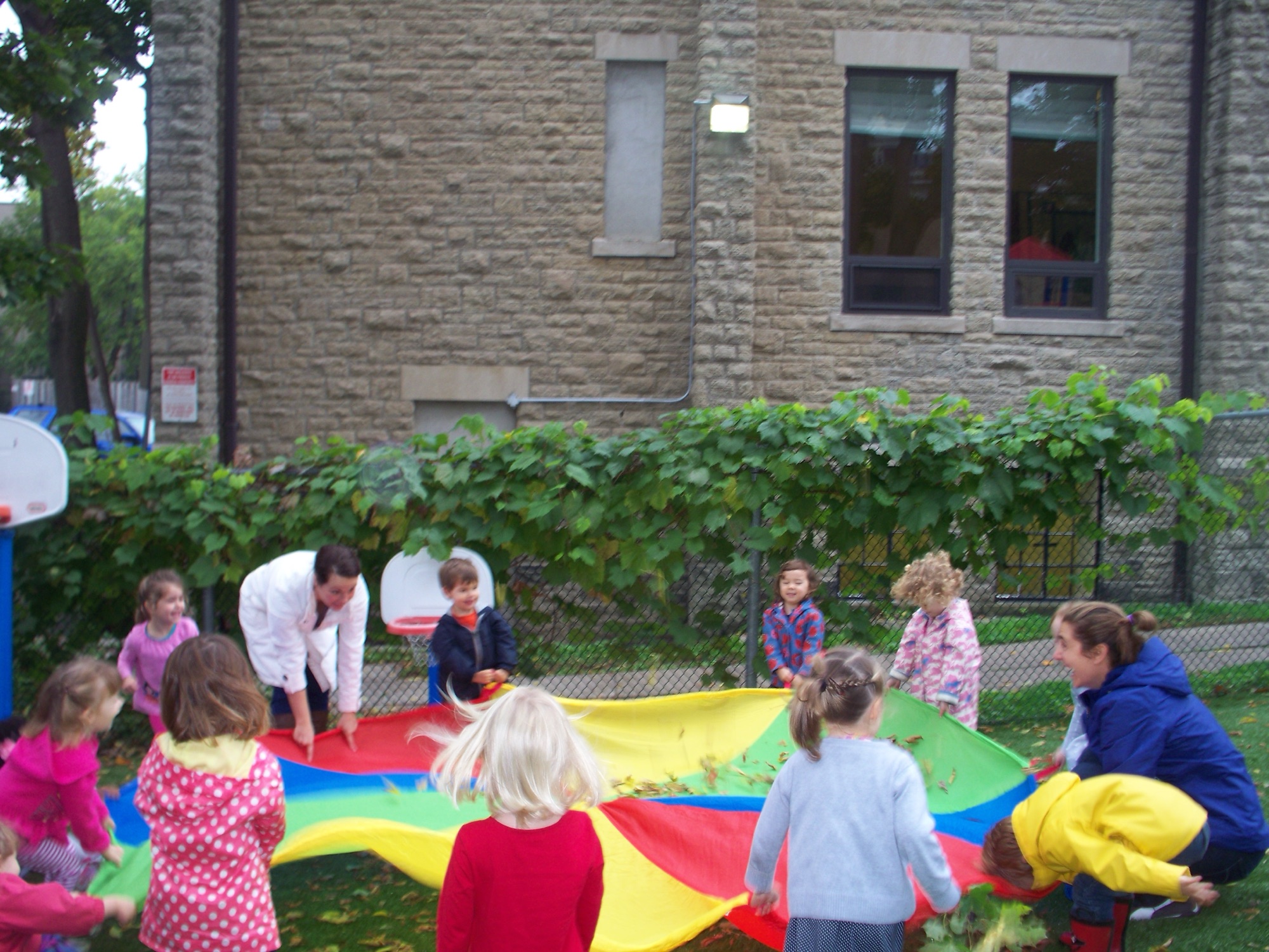 Children and educators with a parachute in the yard