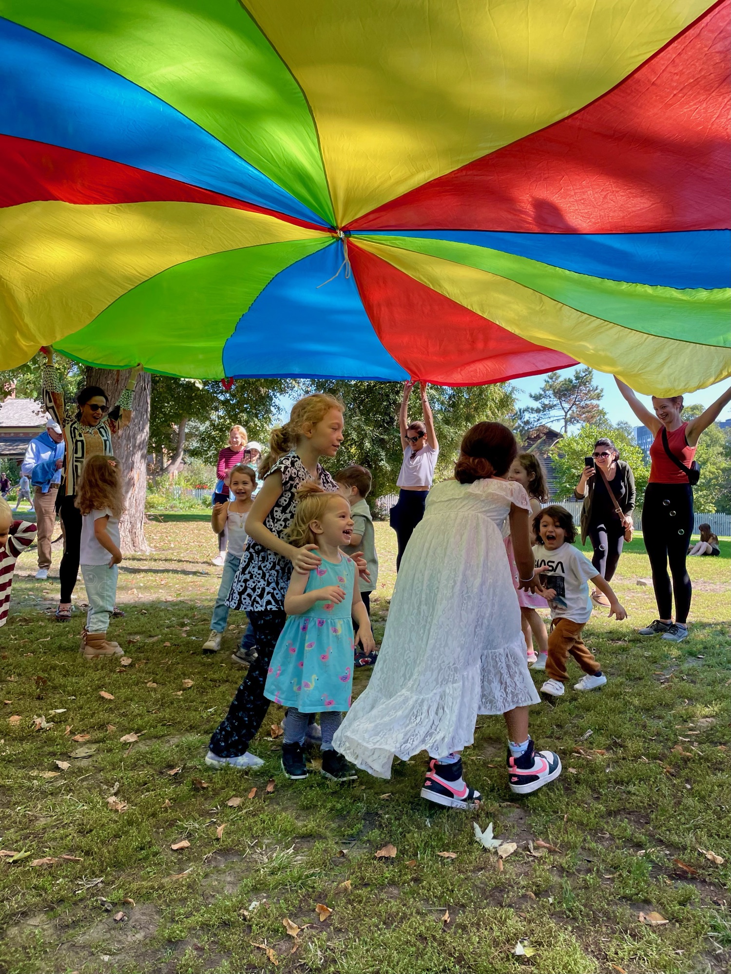 Children playing with the parachute at summer camp