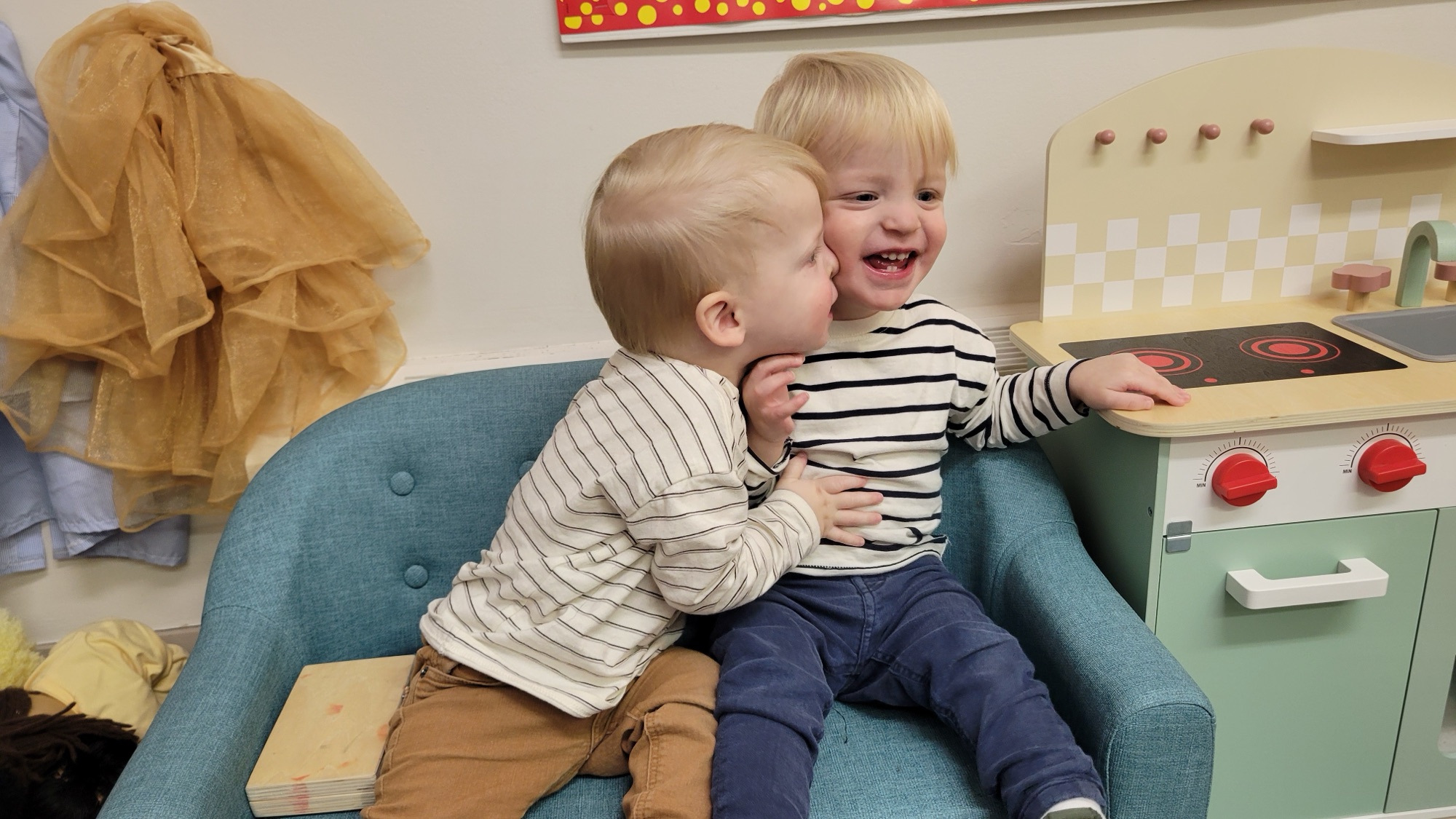 A toddler laughing on the classroom couch