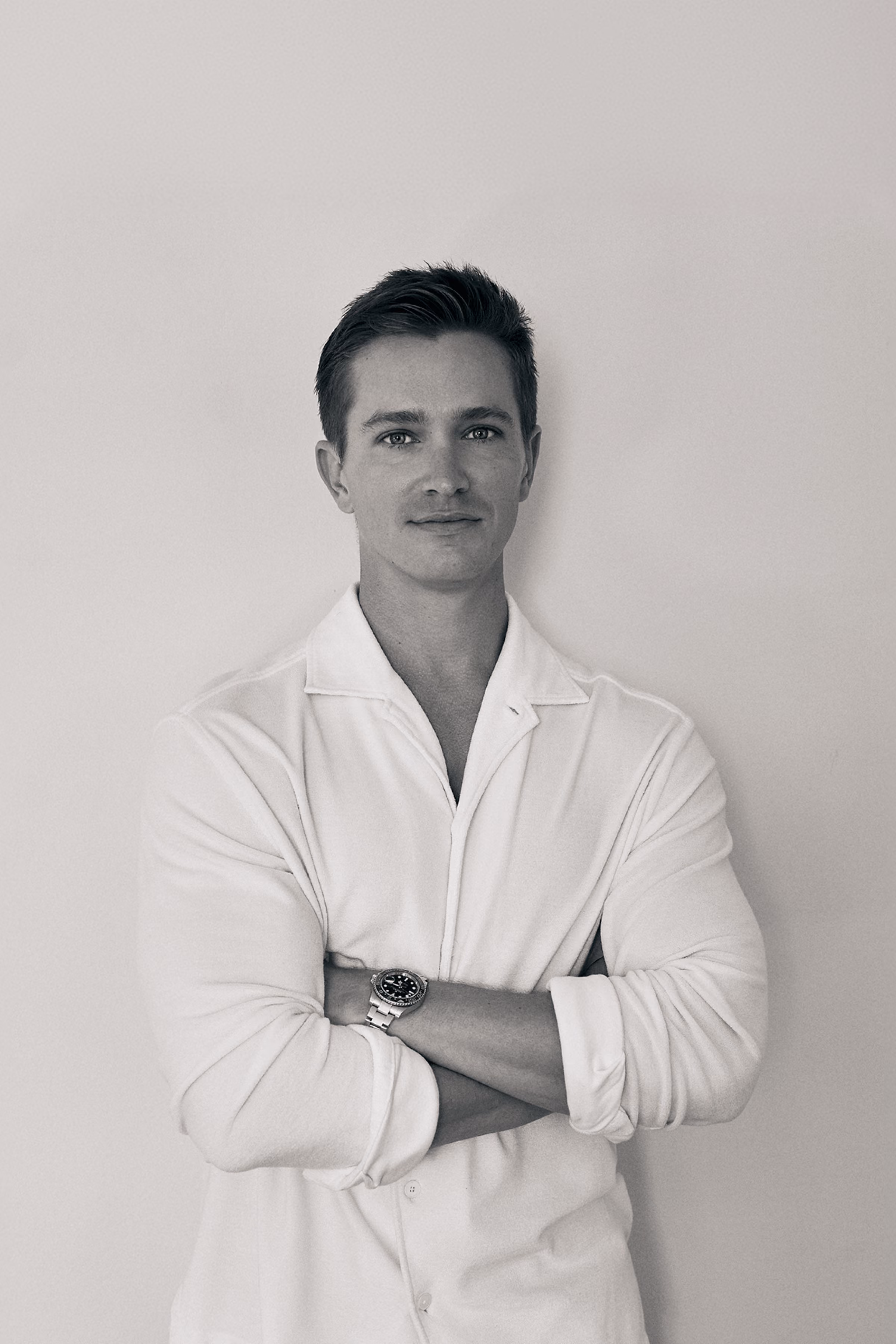 Black and white portrait of Kelan with arms crossed.