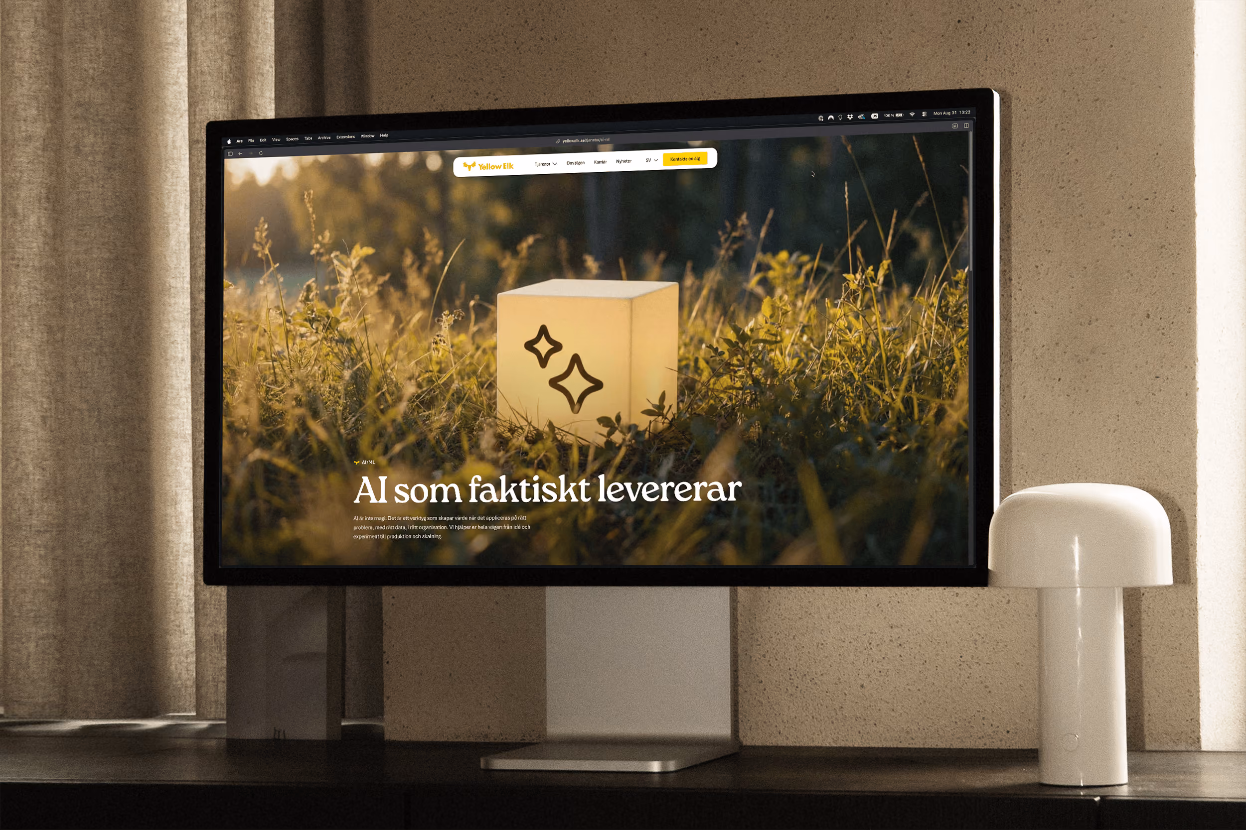 Large computer display on desk showing website with glowing cube in grass and Swedish text about AI.