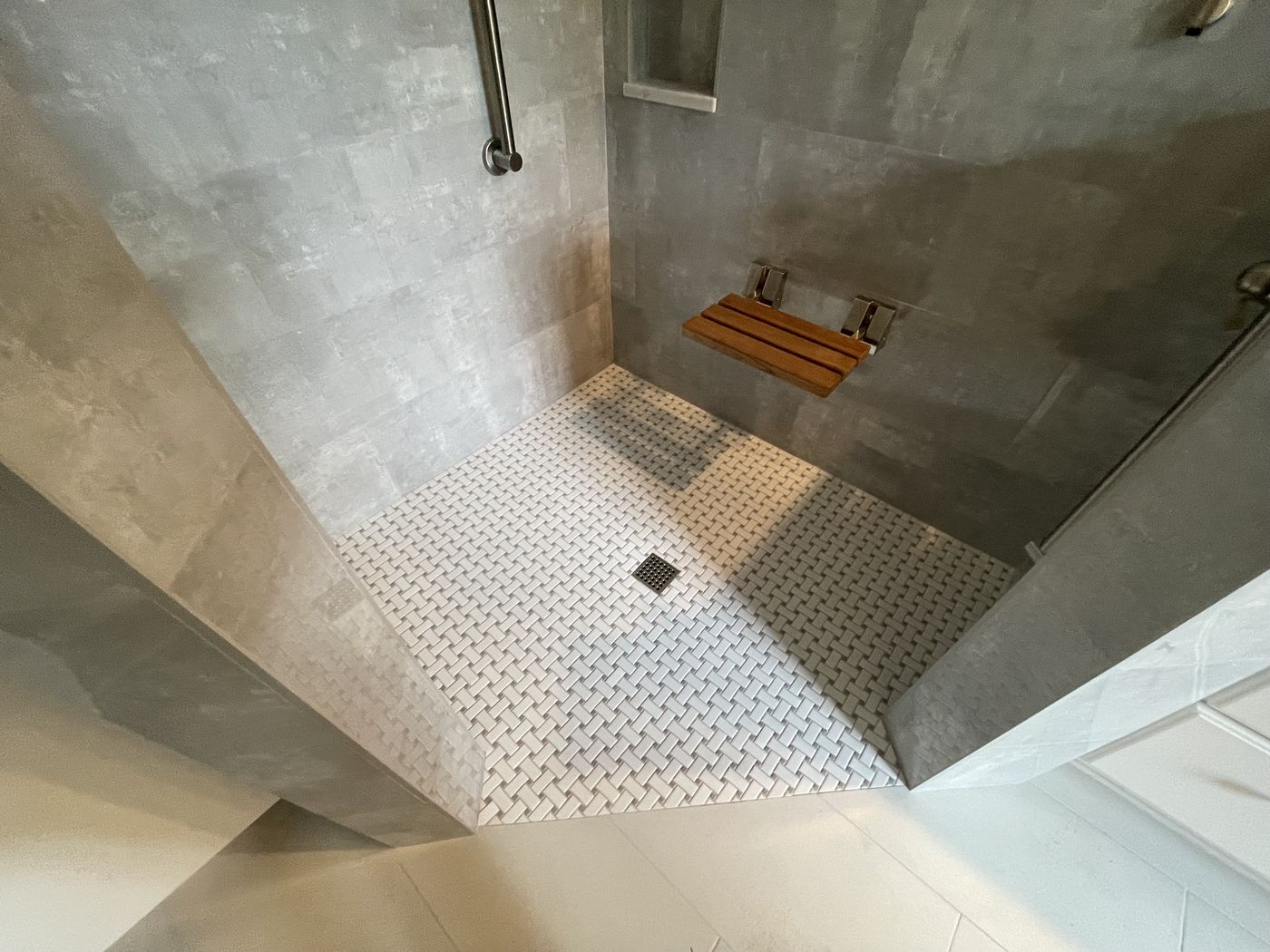 Curbless tile shower with fold-down teak seat — Daybreak Construction
