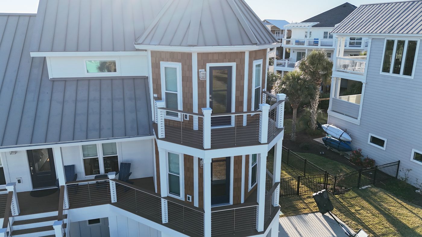 Aerial view of a custom home with turret and standing-seam roof — Daybreak Construction