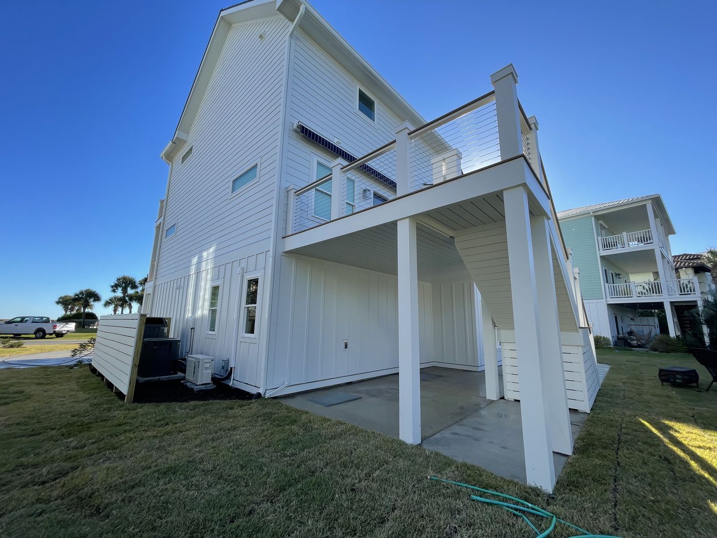 Custom coastal home with cable-rail deck and covered patio — Daybreak Construction