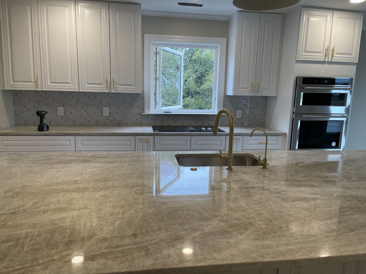 Quartz kitchen island with brass faucet — Daybreak Construction