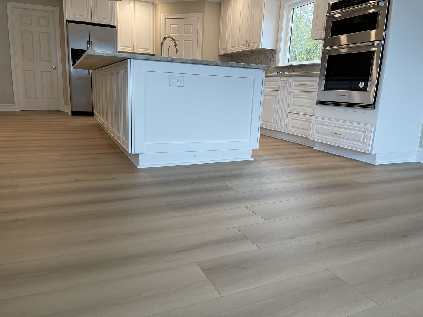 Custom kitchen island and wide-plank flooring — Daybreak Construction
