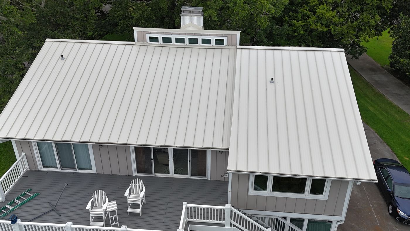 Drone view of a standing-seam metal roof near the coast — Daybreak Construction