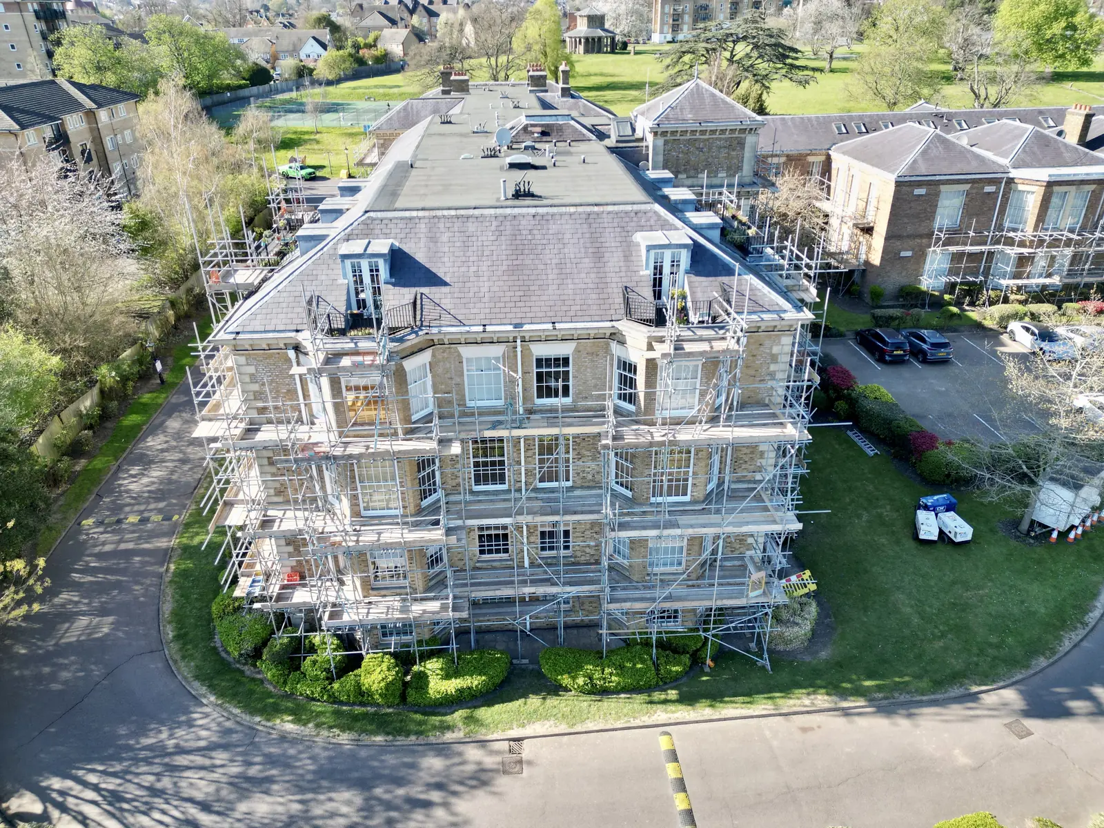 Aerial view of a scaffolded stone building during exterior refurbishment.