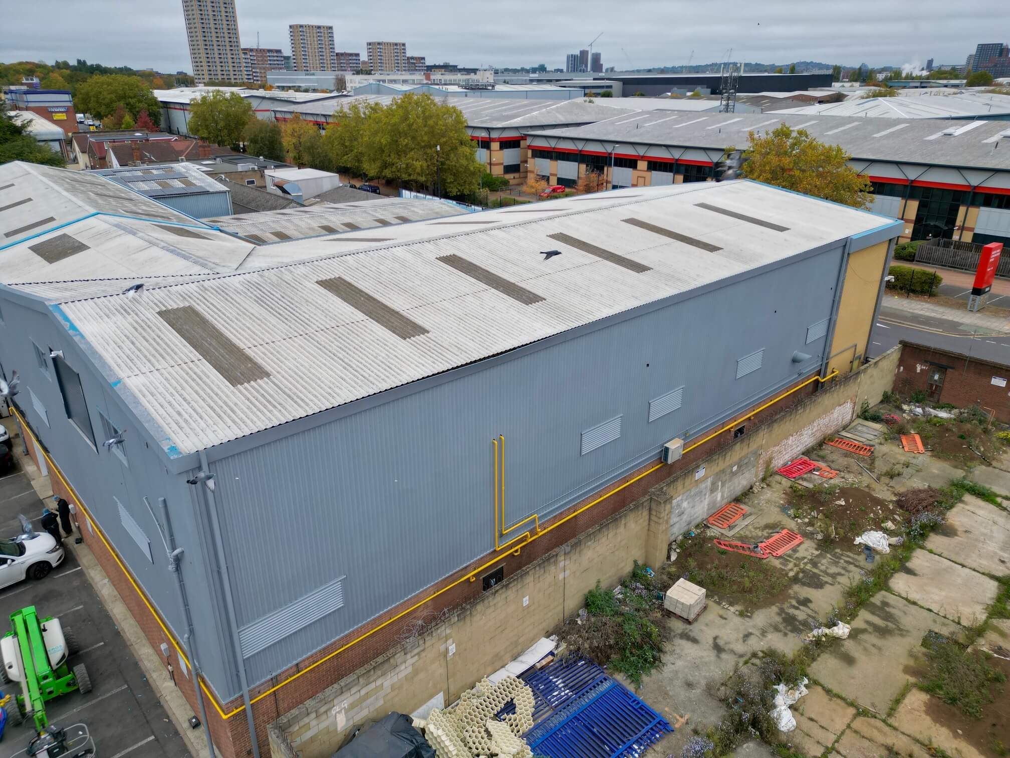 Grey-coated industrial wall cladding beneath a profiled roof, viewed from above.